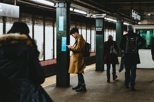 man using phone on the subway